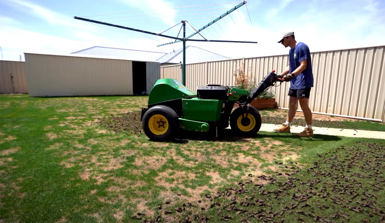 A man aerating his lawn.